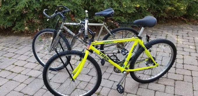 2 mountain bikes; yellow one with basket, white onewith rear luggage rack